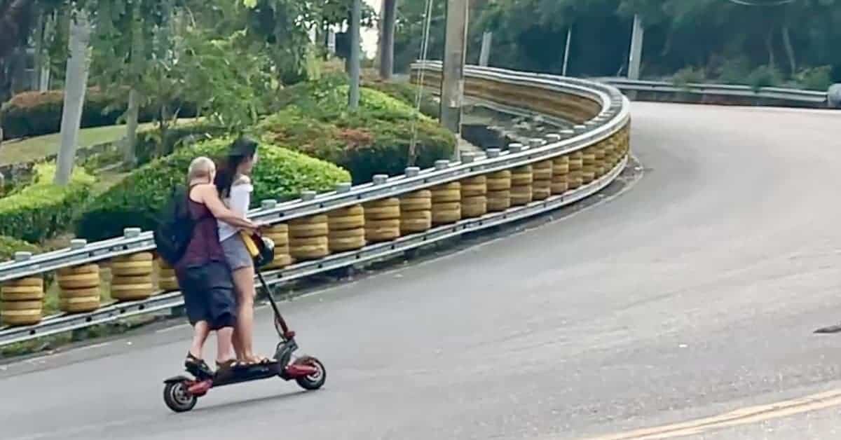 a man riding electric scooter uphill with a woman